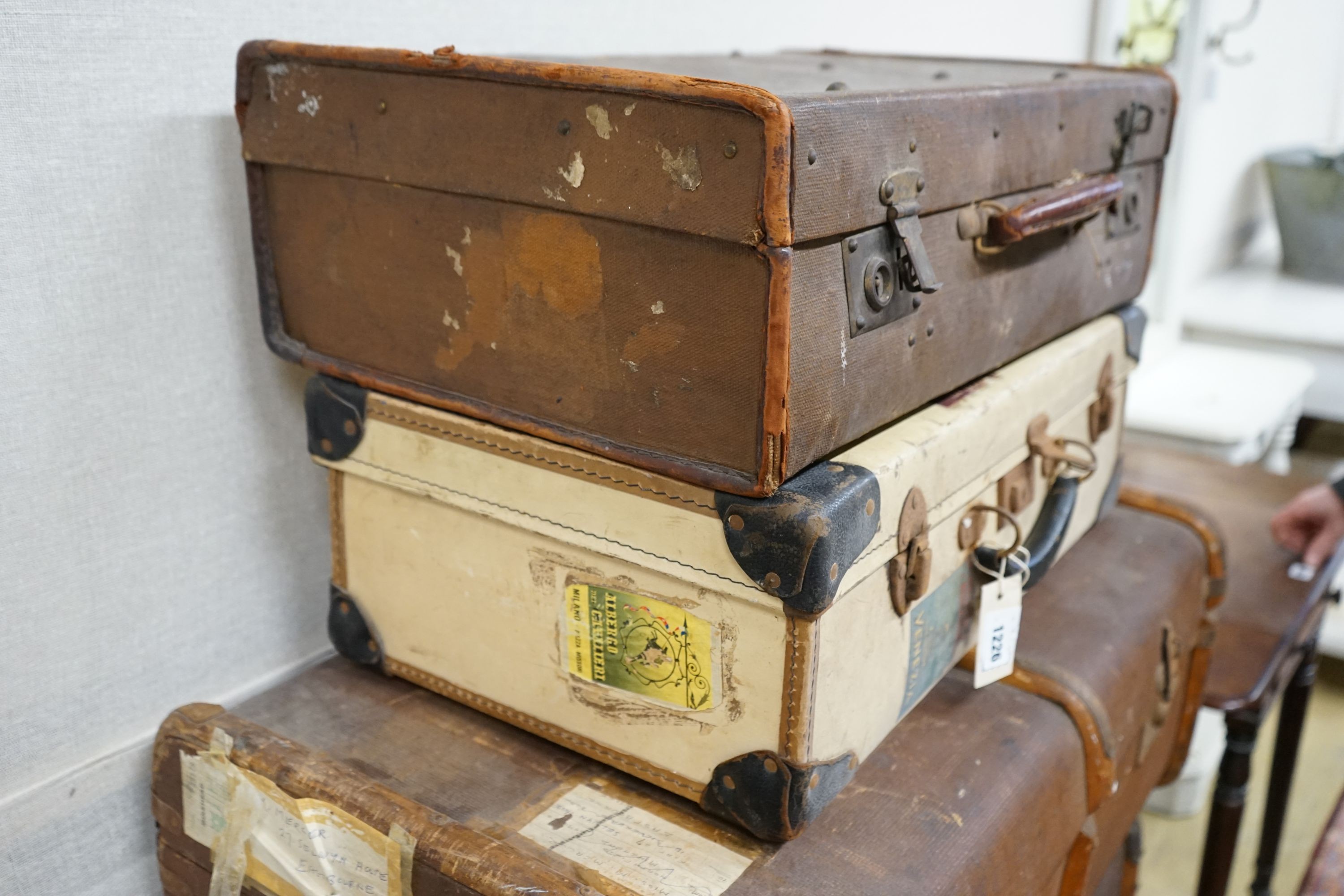 A collection of five vintage suitcases, largest width 83cm